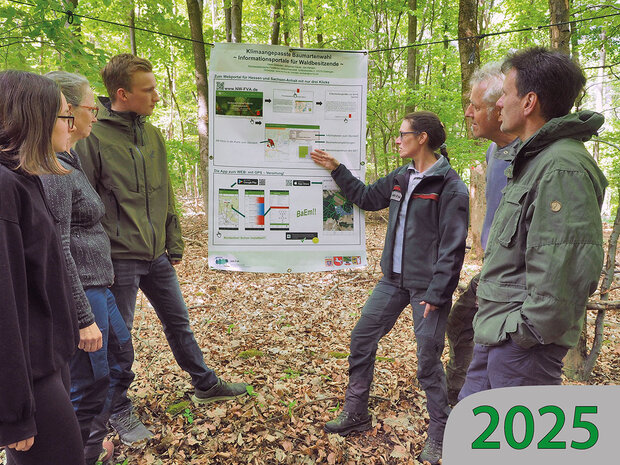 Das Bild zeigt Waldbesitzende vor einem Poster bei einer Fortbildung im Wald.